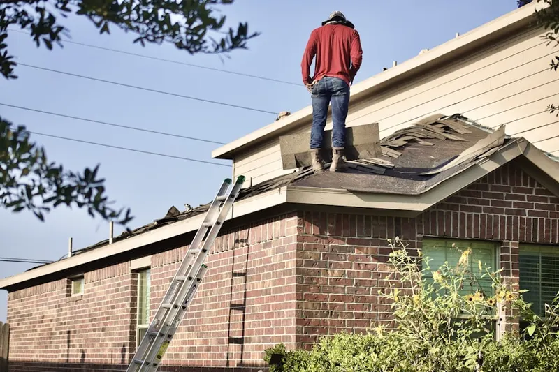 Professional roofer working on a residential roof in North Springs Apartments
